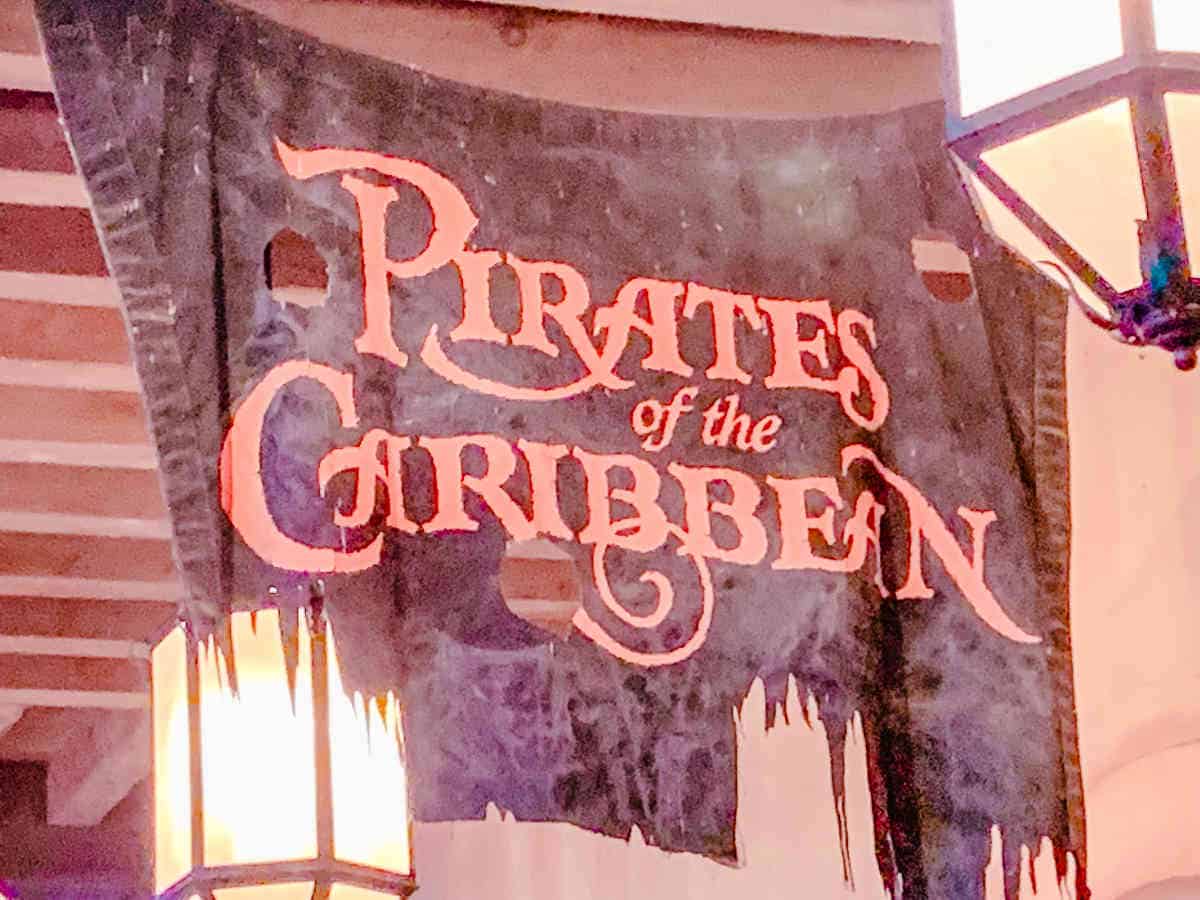 Entrance sign on a ripped up piece of cloth to the Pirates of the Caribbean ride in Magic Kingdom