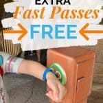 Little girl touching bracelet to a box that lights up green with a Mickey Mouse head.